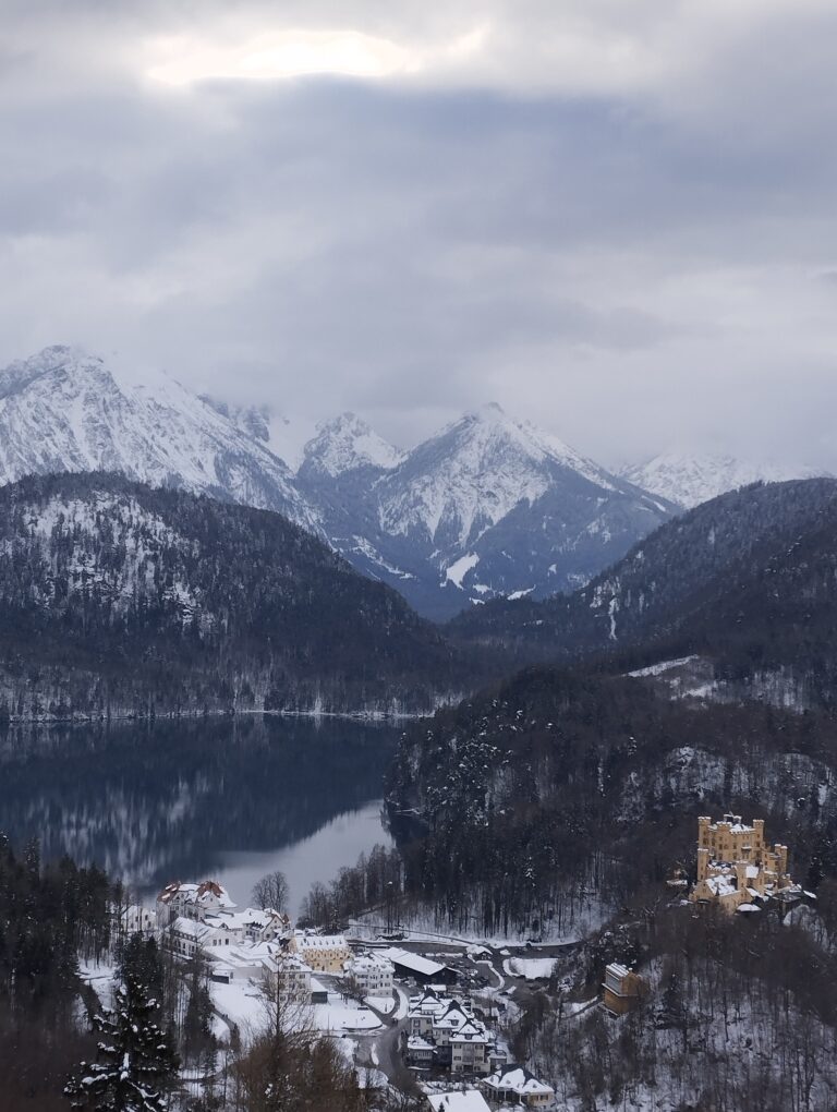 Snježni planinski krajolik s jezerom i malim gradom u dolini, koji simbolizira mir, sigurnost i svjesni izbor vlastitog puta